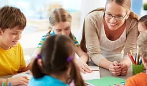 Images shows a teacher and several students talking