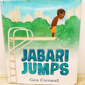Images shows a young boy standing on a diving board.